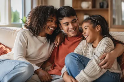 Three Siblings Laughing on Living Room Sofa