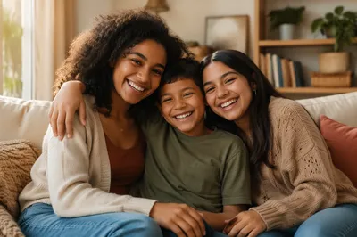 Three Siblings Laughing on Sunlit Sofa