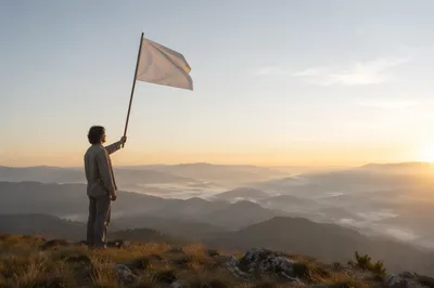 Person Raising White Flag at Sunrise