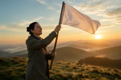 Person Raising White Flag at Sunrise