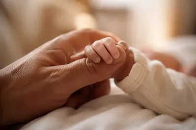 Newborn Hand Holding Adult Finger in Trust