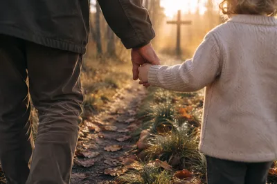 Child Holding Adult Hand Toward Cross