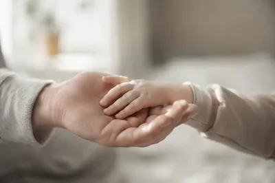 Child Holding Adult Hand in Trust
