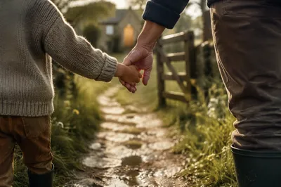 Child Holding Adult Hand on Rainy Path