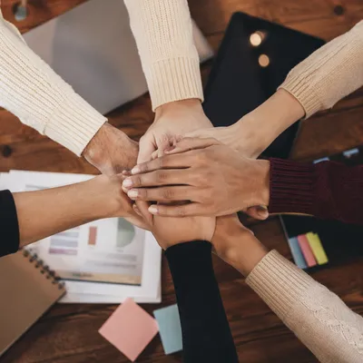 Diverse Hands United on Wooden Table