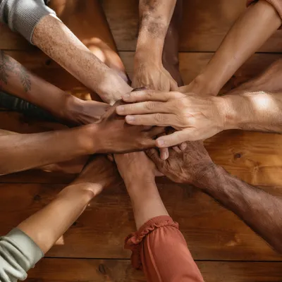 Many Hands Stacked in Quiet Unity