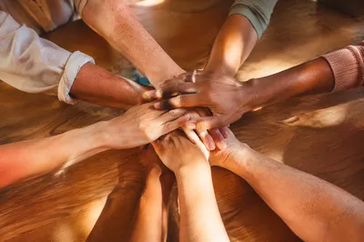 Many Hands Stacked in Quiet Unity