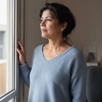 Thoughtful Woman by Apartment Window