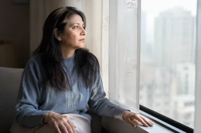 Thoughtful Woman by Apartment Window