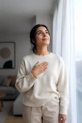 Hopeful Woman by Window in Soft Light