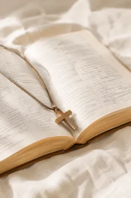 Open Bible with Wooden Cross on Linen