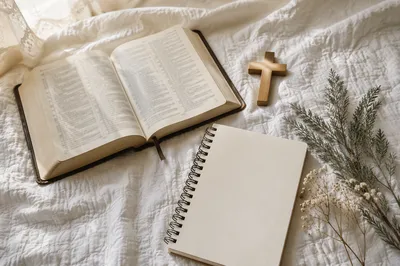 Open Bible and Wooden Cross on Linen