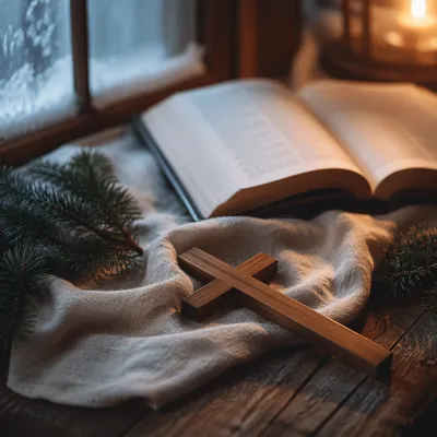Wooden Cross Beside Bible on Evergreen Linen