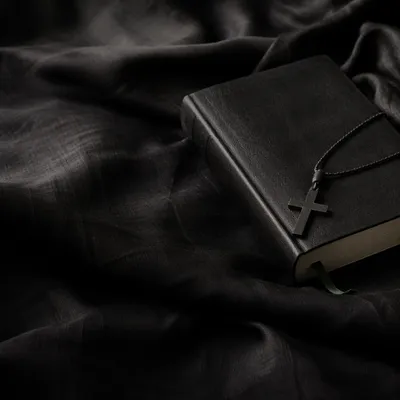 Black Bible and Cross on Linen