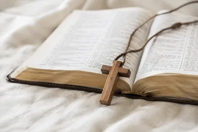 Wooden Cross on Open Scripture and Linen