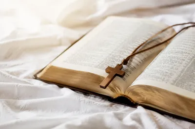 Open Bible with Wooden Cross on Linen
