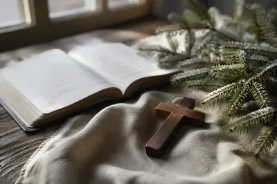 Open Bible with Wooden Cross and Evergreen