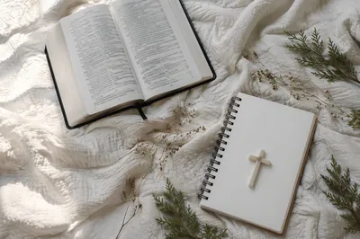 Open Bible and Ivory Cross on Linen