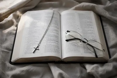 Open Bible with Silver Cross on Linen