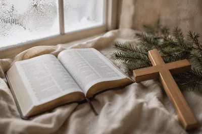 Open Bible and Wooden Cross on Linen
