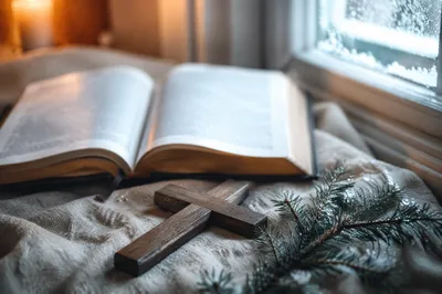 Open Bible and Wooden Cross on Linen