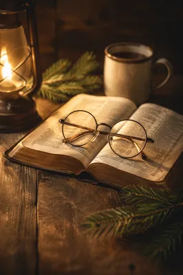 Open Bible and Glasses in Warm Lamplight
