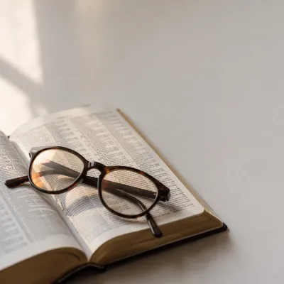 Open Bible with Glasses in Warm Light