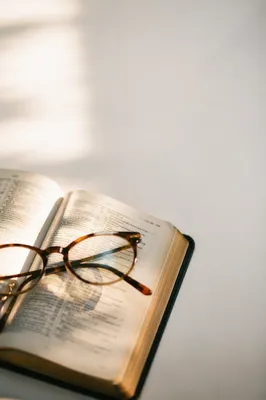 Open Bible with Reading Glasses in Warm Light