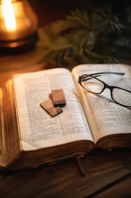 Open Bible with Glasses in Warm Light