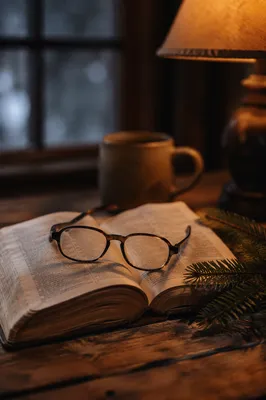 Open Bible with Glasses in Warm Lamplight