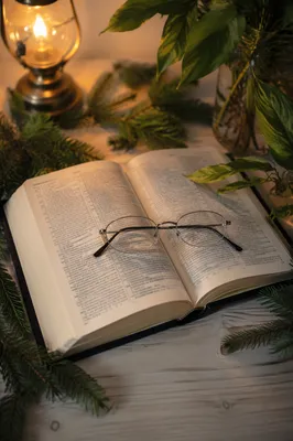 Open Bible with Glasses in Warm Lamplight