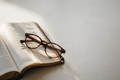 Open Bible with Glasses in Warm Light