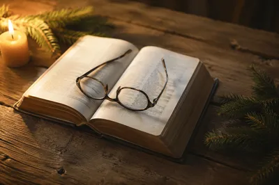 Open Bible With Glasses in Warm Light