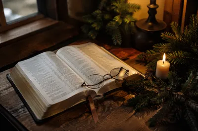 Open Bible with Glasses in Warm Light