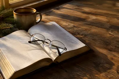 Open Bible with Glasses in Warm Light
