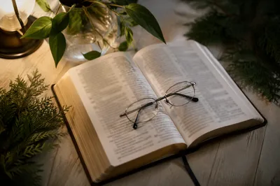 Open Bible With Reading Glasses in Warm Light
