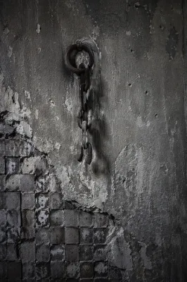 Broken Rusted Chain on Weathered Wall