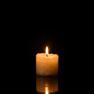 Burning Ivory Candle on Dark Background