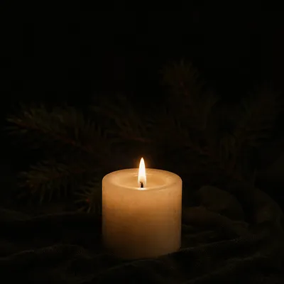 Burning Ivory Candle in Winter Darkness