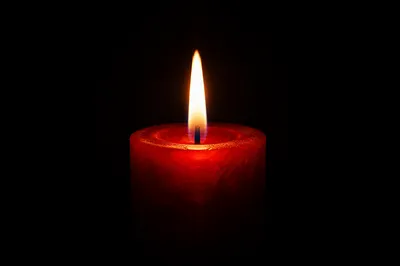 Red Candle Flame in Quiet Darkness