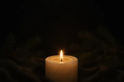 Burning Ivory Candle in Winter Darkness