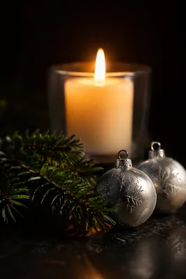 Burning Candle with Evergreen and Silver Ornaments