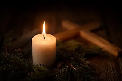 Burning Candle with Evergreen and Wooden Cross