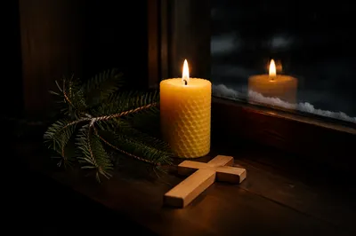 Burning Candle with Cross and Evergreen