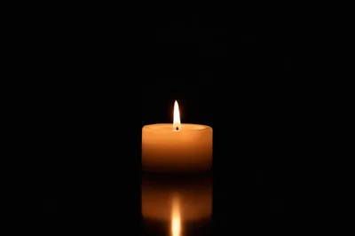 Burning Ivory Candle on Dark Background