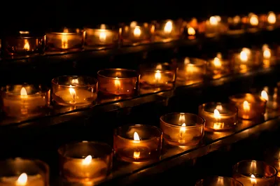 Votive Candles Glowing in Quiet Darkness
