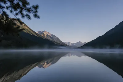 Calm Morning Lake Reflection in Evergreen Mountains