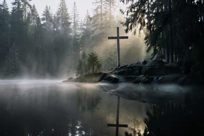 Wooden Cross Reflected in Misty Forest Pond