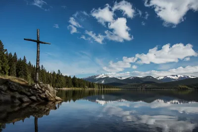 Wooden Cross Reflected on Mountain Lake