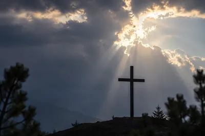 Cross Silhouette Beneath Breaking Light Rays